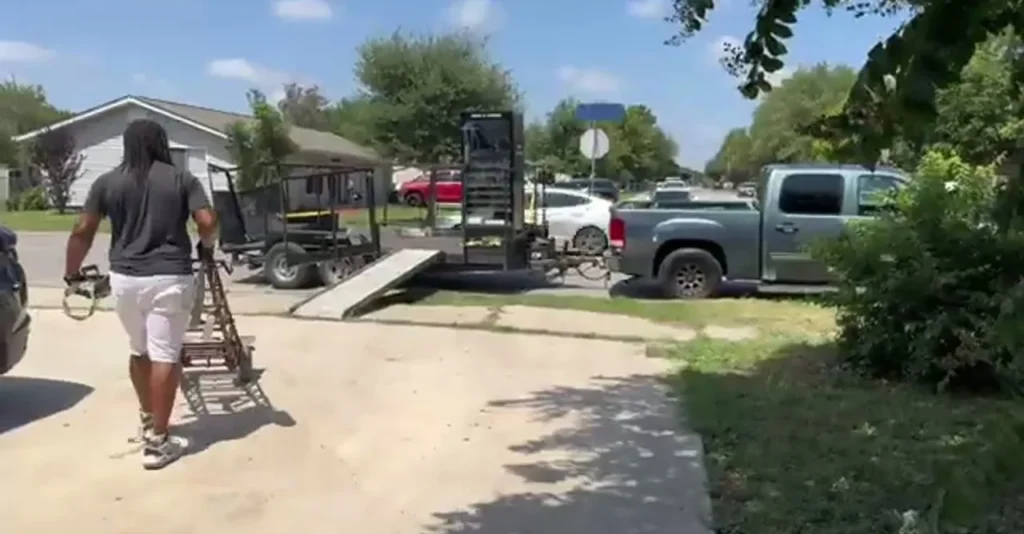 Mover rolling a hand truck back toward the trailer ramp