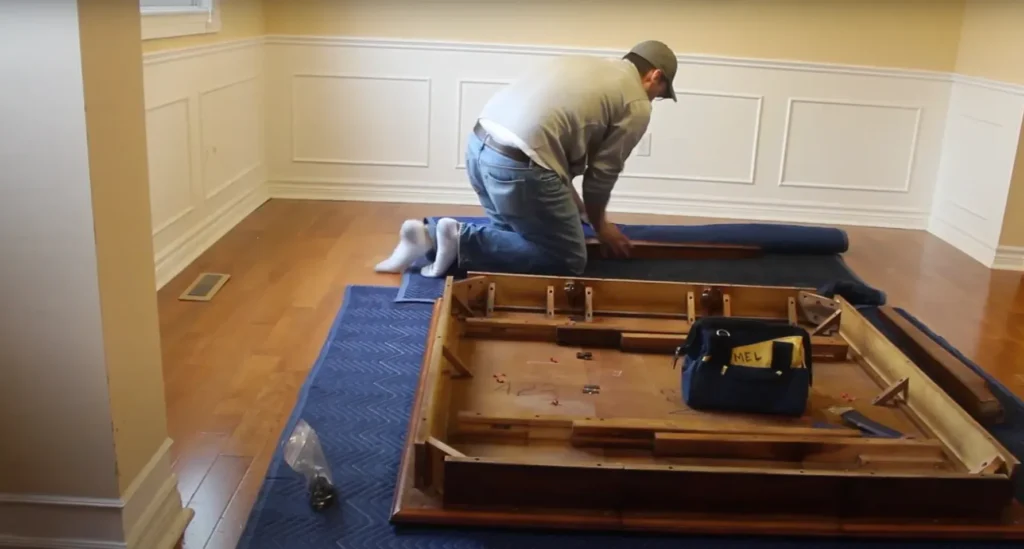 Mover disassembling a table frame on moving pads